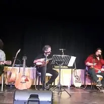 Trio auf der Bühne im Scheinwerferlicht