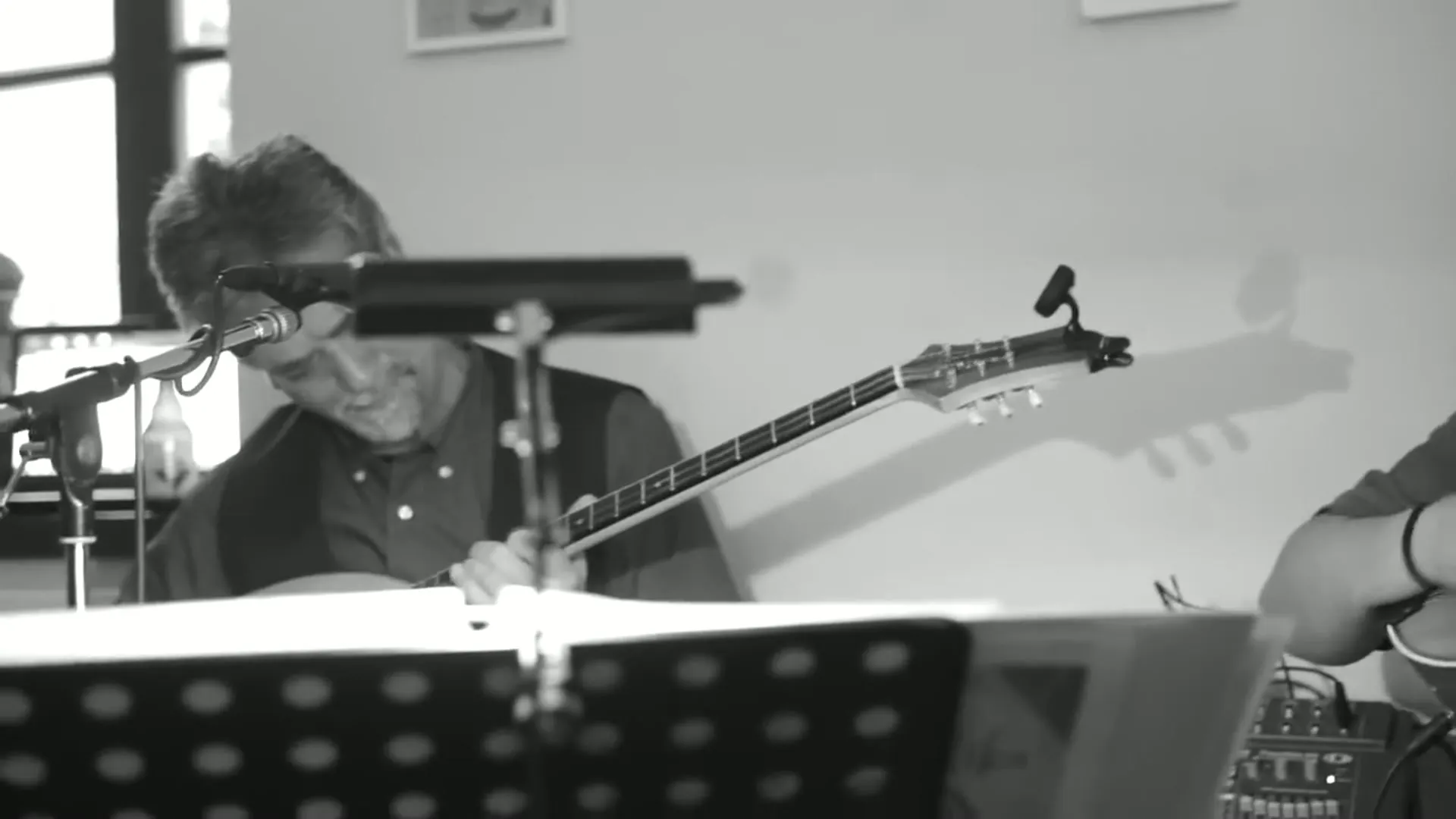 Kostas Pittadakis über seine Bouzouki gebeugt, schwarzweiß