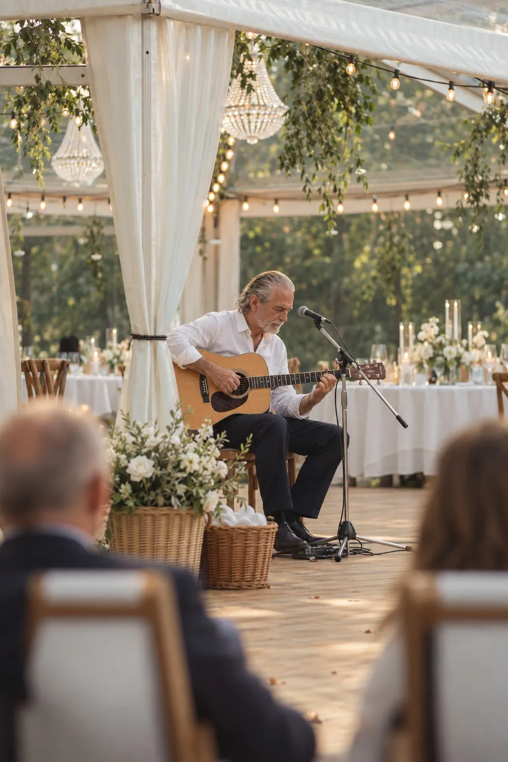 Kostas Pittadakis spielt bei einer Hochzeit unter einem Pavillon, Gäste sitzen an gedeckten Tischen